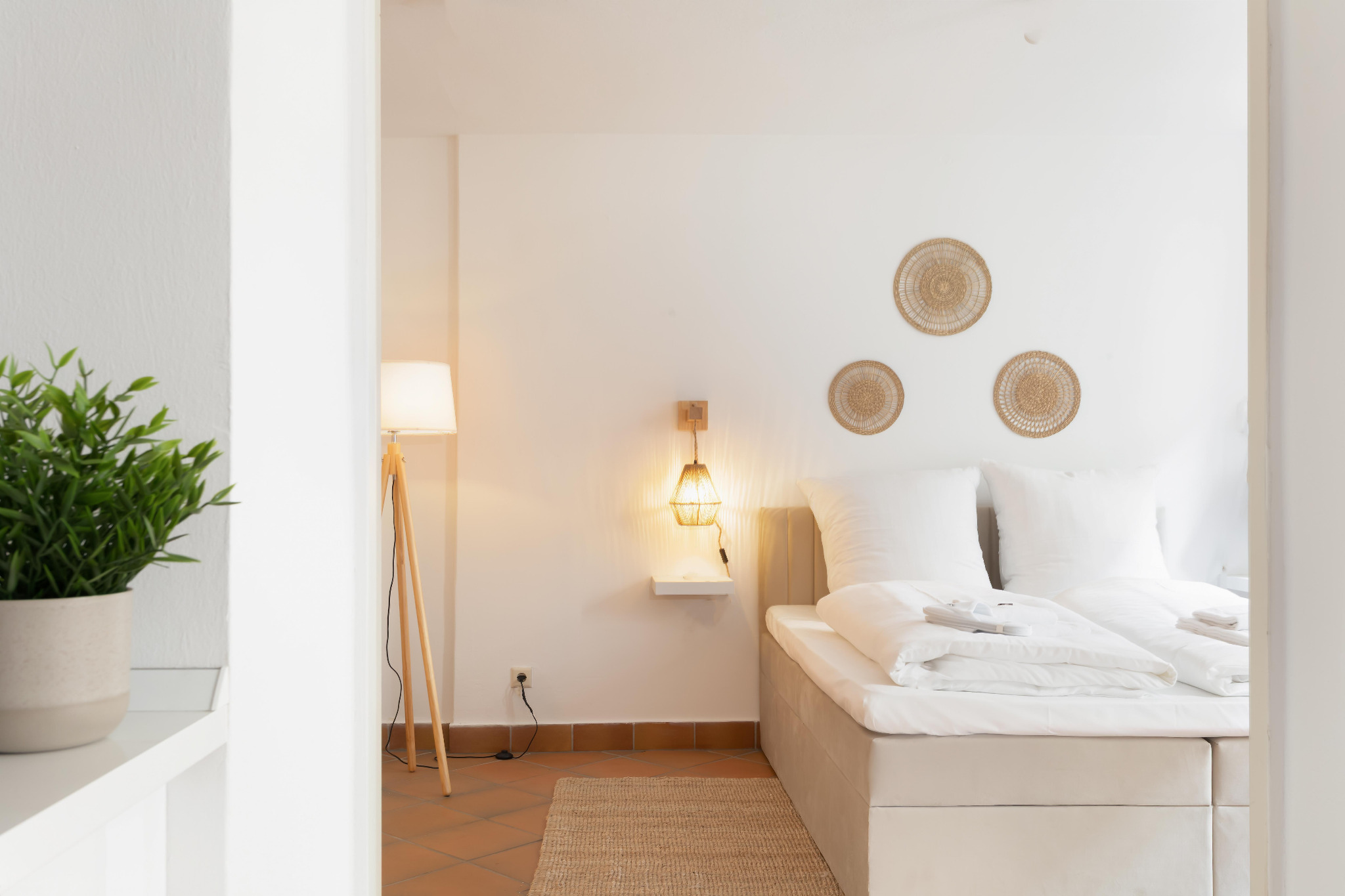 Helles Schlafzimmer mit natürlichen Materialien in George’s Service Apartments